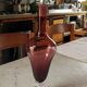 Purple-colored liquor-blown glass decanter with carved foot