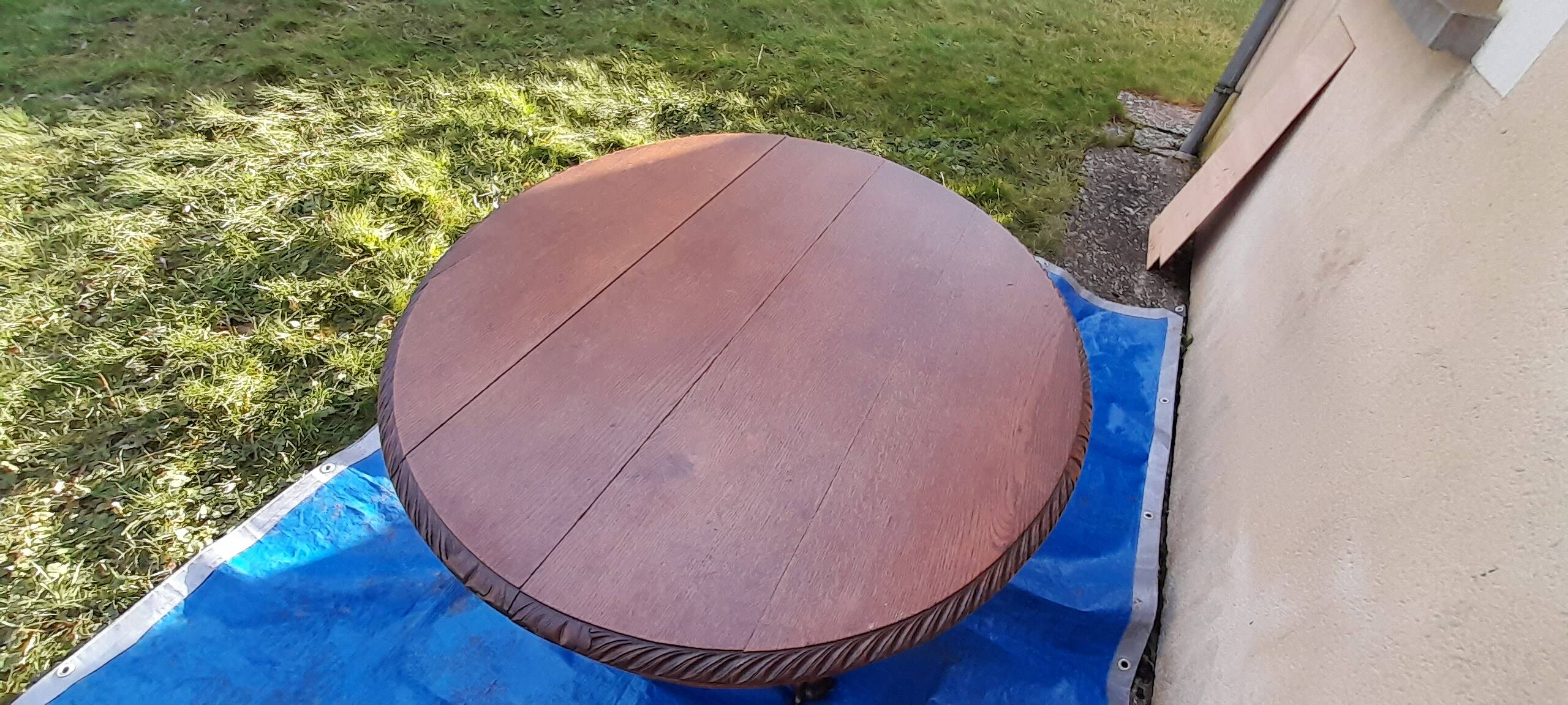 Round table in molded and carved oak with quill decoration, central shaft with 4 runners
