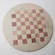 Vintage 1980s round chess set in marble, with a beige and pink marble board and wooden pieces.