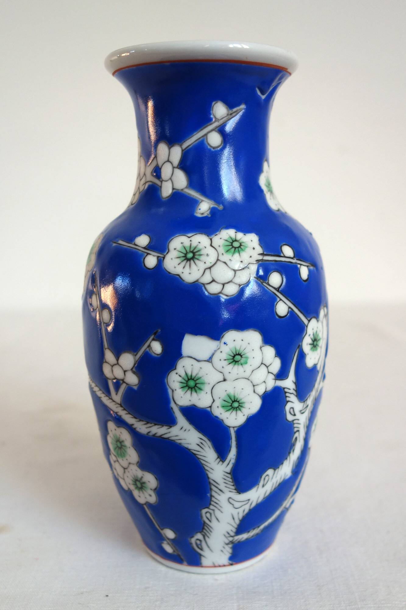 Old blue vase with vintage porcelain cherry blossoms