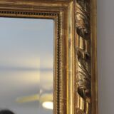 Miroir ancien doré surmonté d'un fronton et glace biseautée