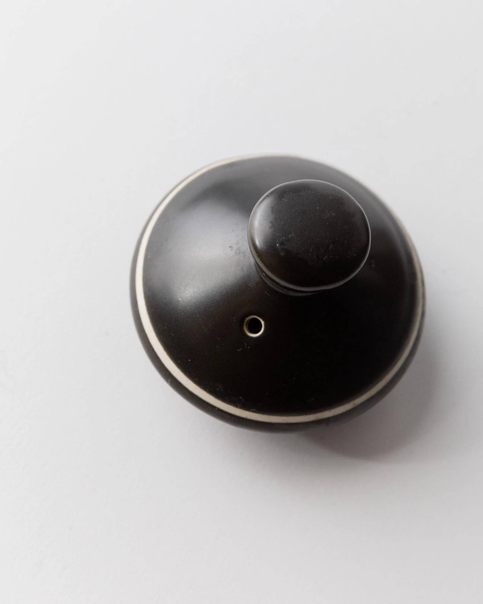 Vintage ceramic teapot from the 1980s, black with white stripes and a metal handle.