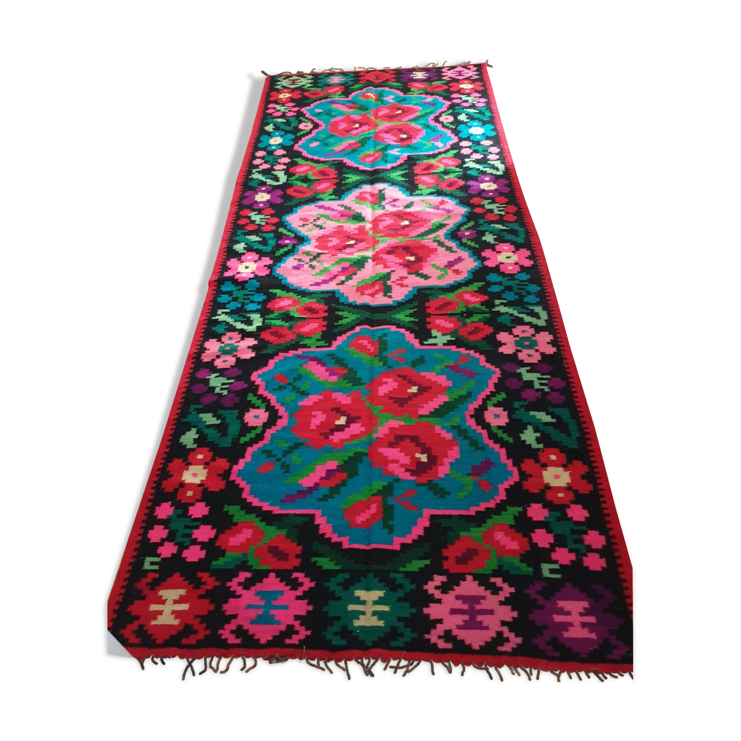 Colorful kilim on black background with floral design