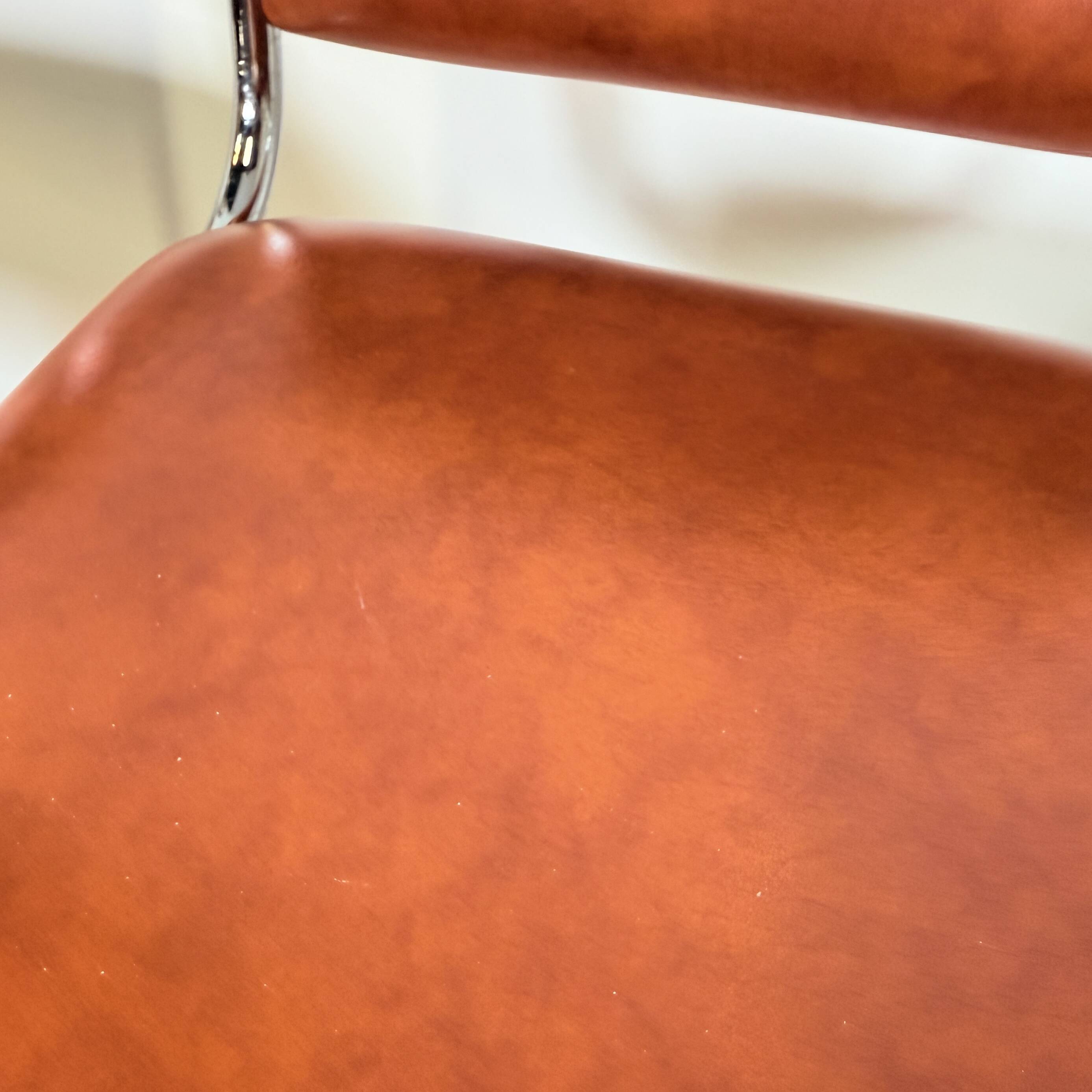 1970s chrome bar stools with cognac-colored faux leather upholstery