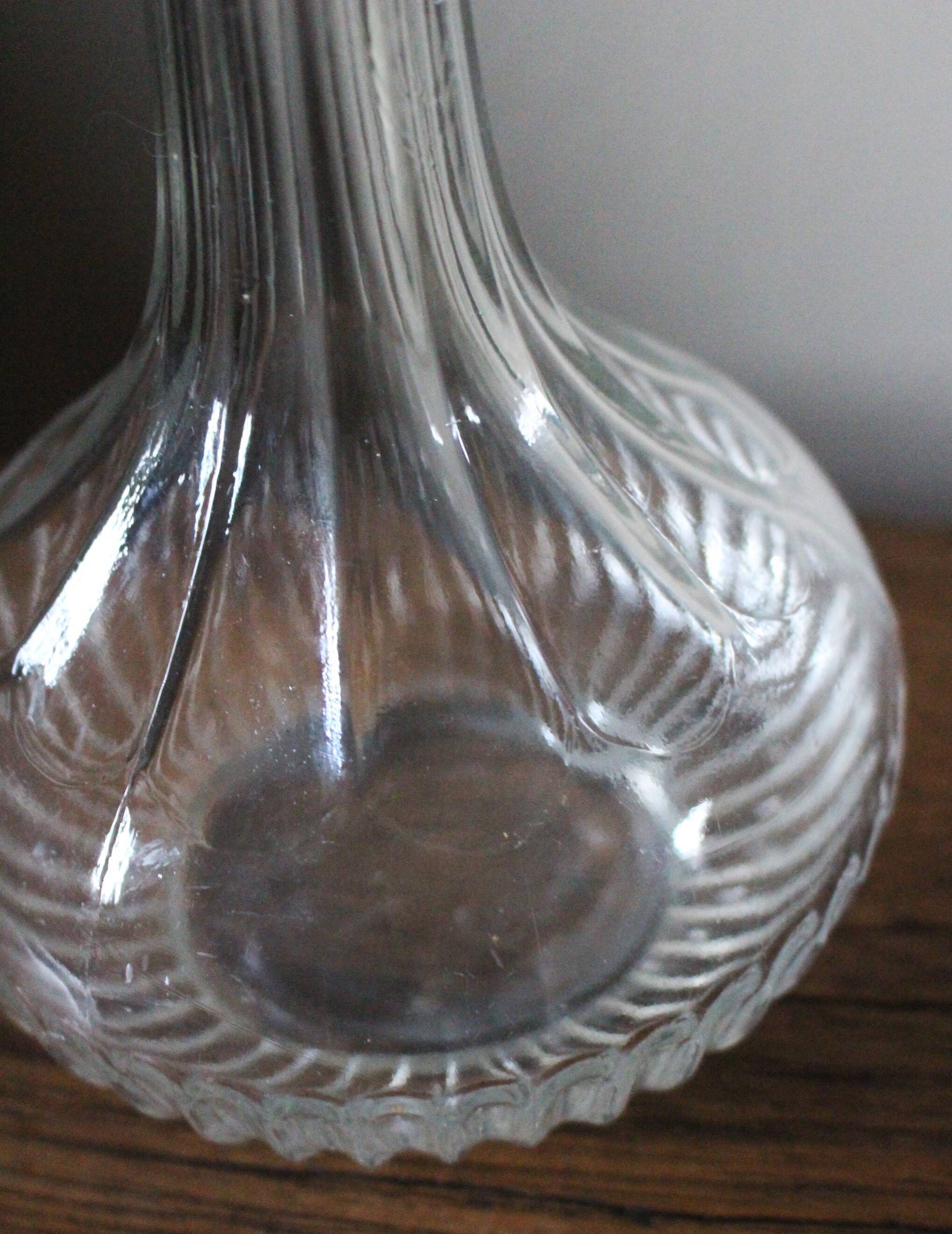 Round-bellied glass carafe with ribbed neck.