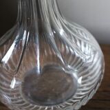 Round-bellied glass carafe with ribbed neck.