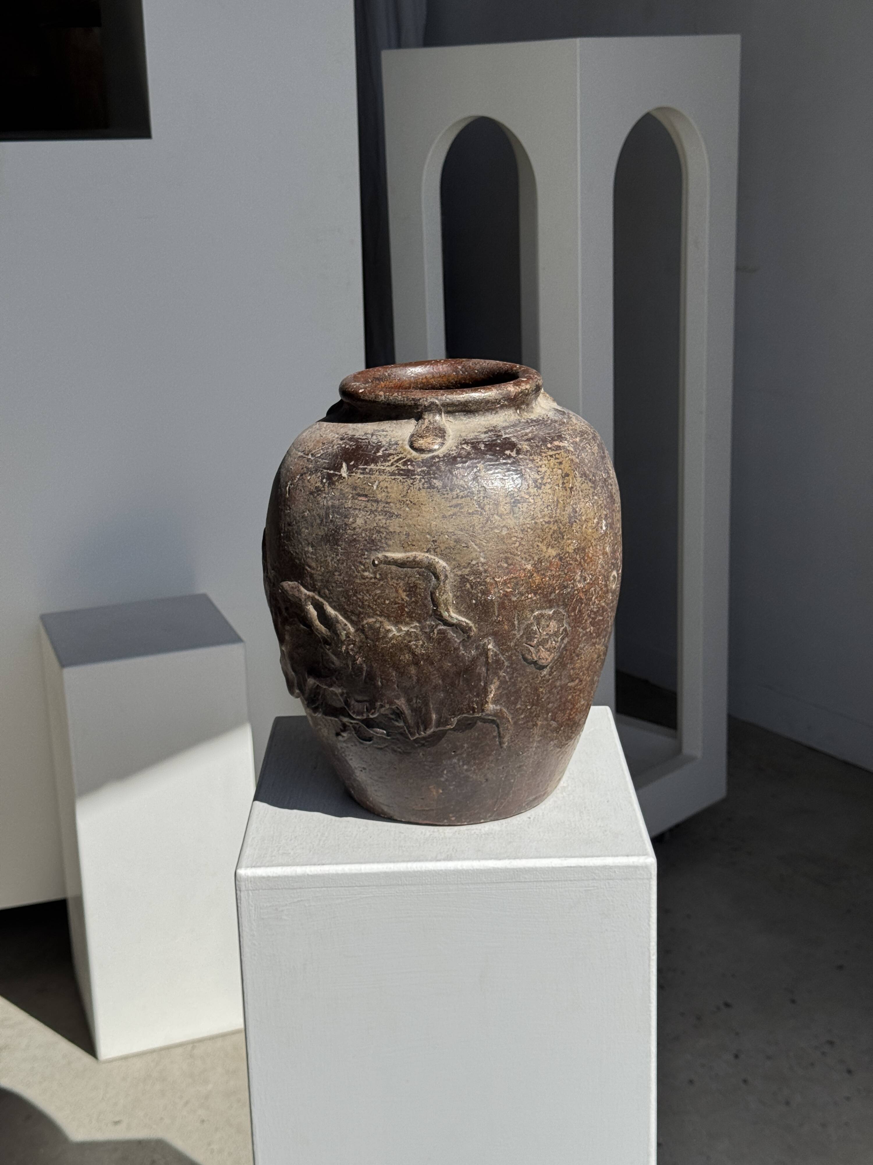 Large traditional Indonesian clay pot featuring a dragon.