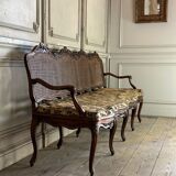 Grande banquette Louis XV en bois naturel mouluré et sculpté, France XVIIIème siècle