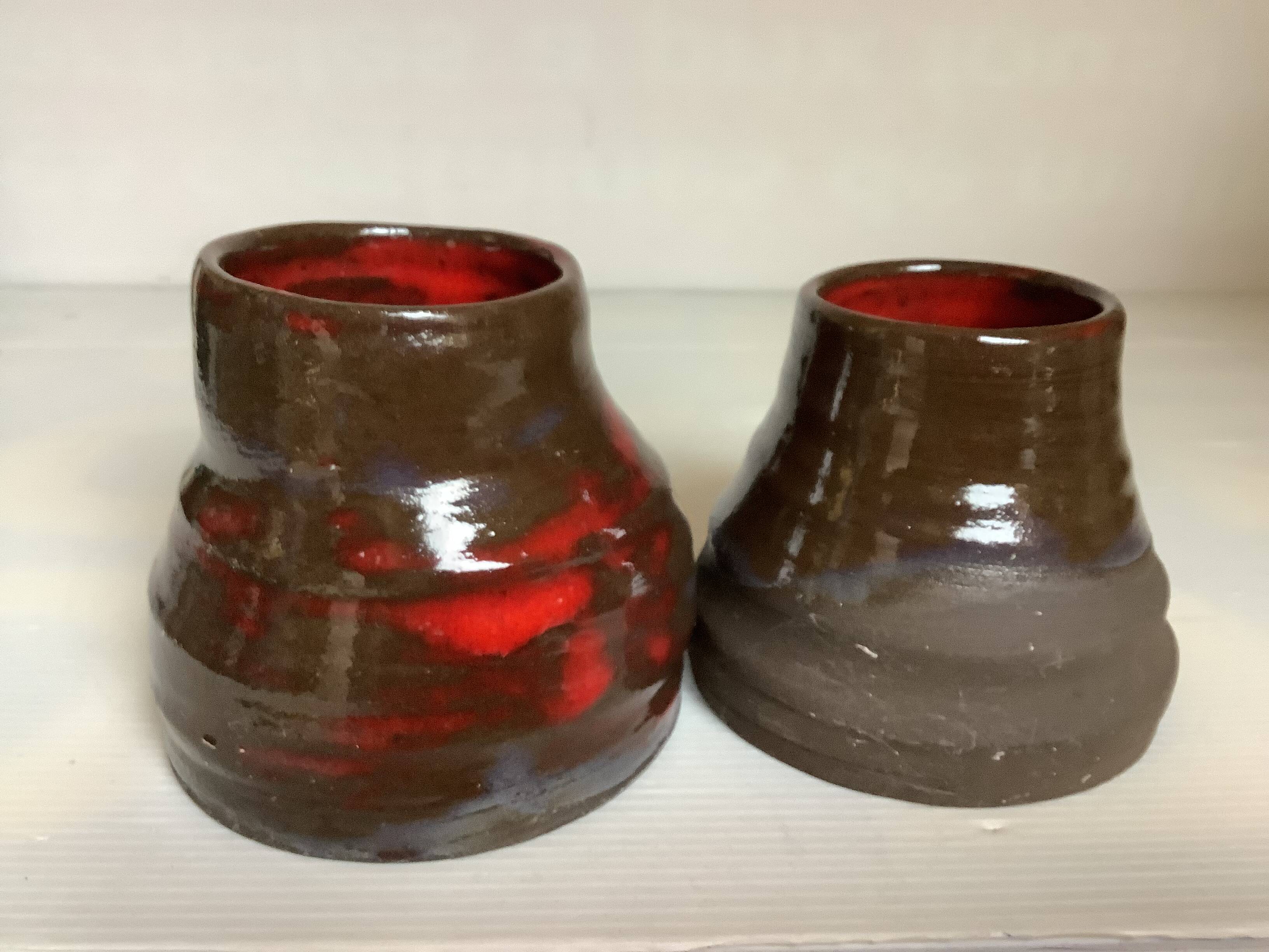 Pair of red vases in the shape of an elephant's foot