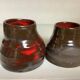 Pair of red vases in the shape of an elephant's foot