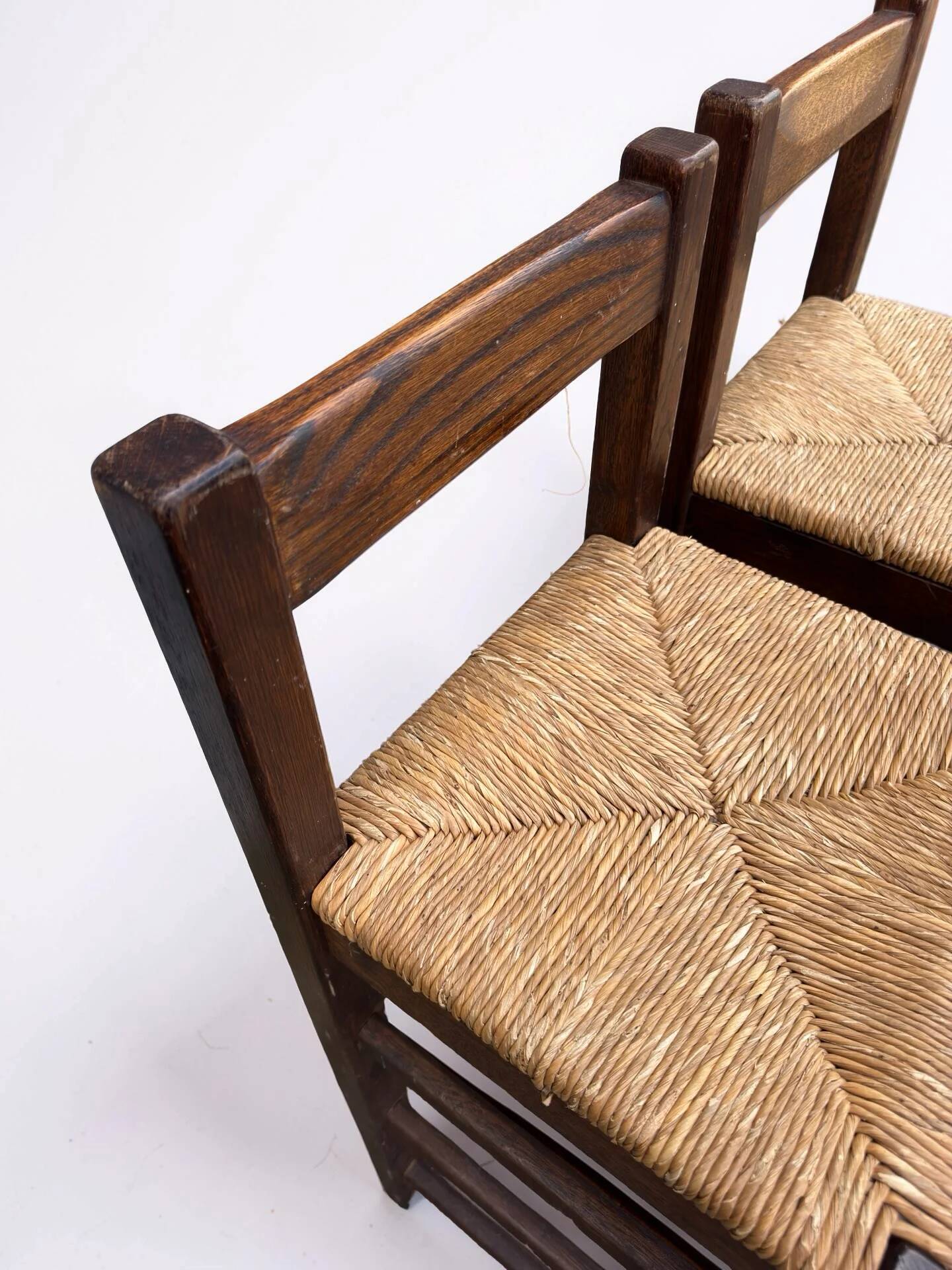 Set of 2 vintage wooden bar stools with woven straw seats.