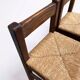 Set of 2 vintage wooden bar stools with woven straw seats.