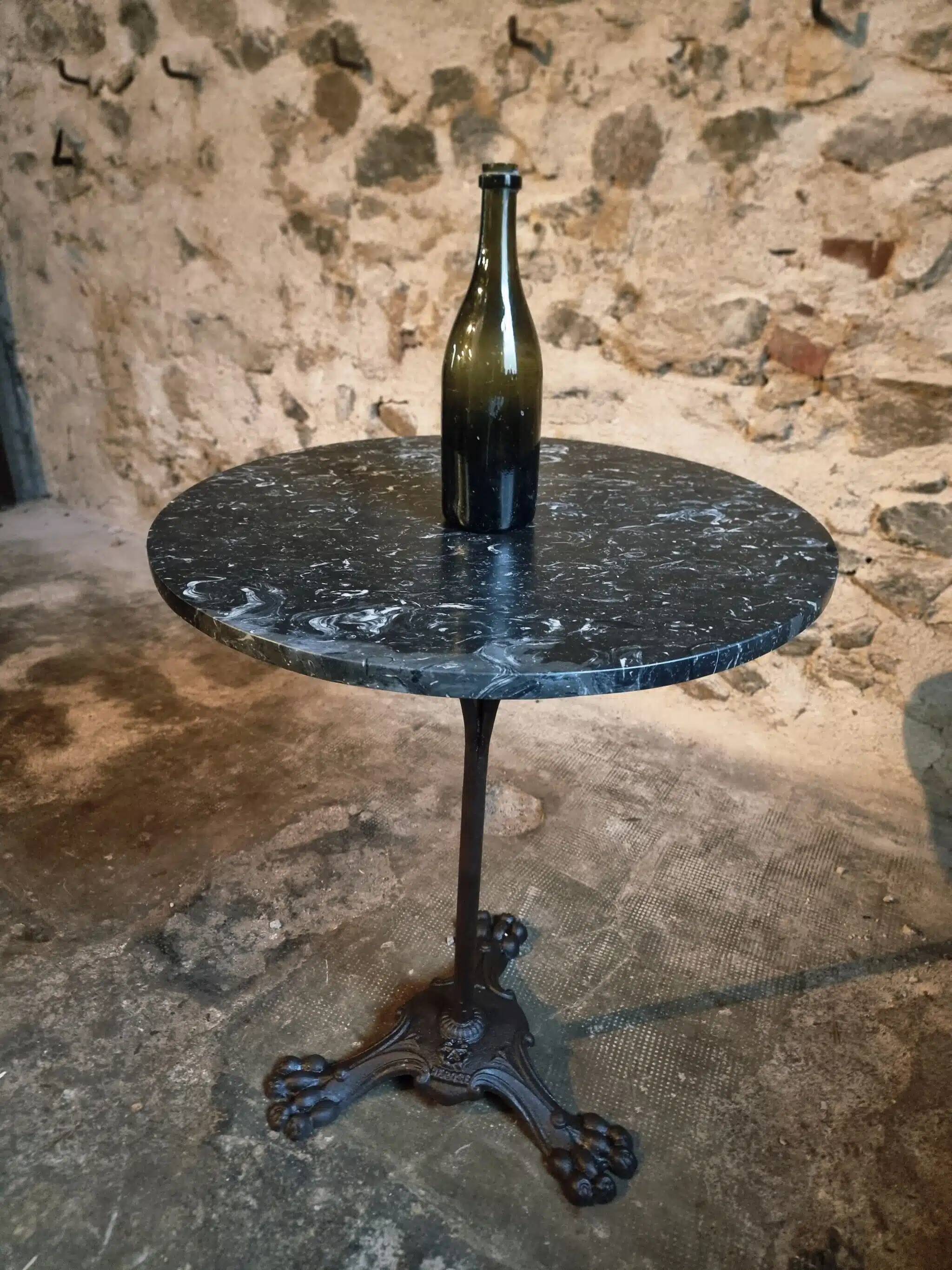Old French bistro table with a marble top and a cast iron base.