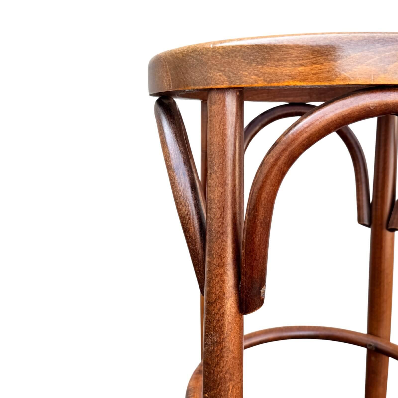 Old high stool in curved wood with caned seat