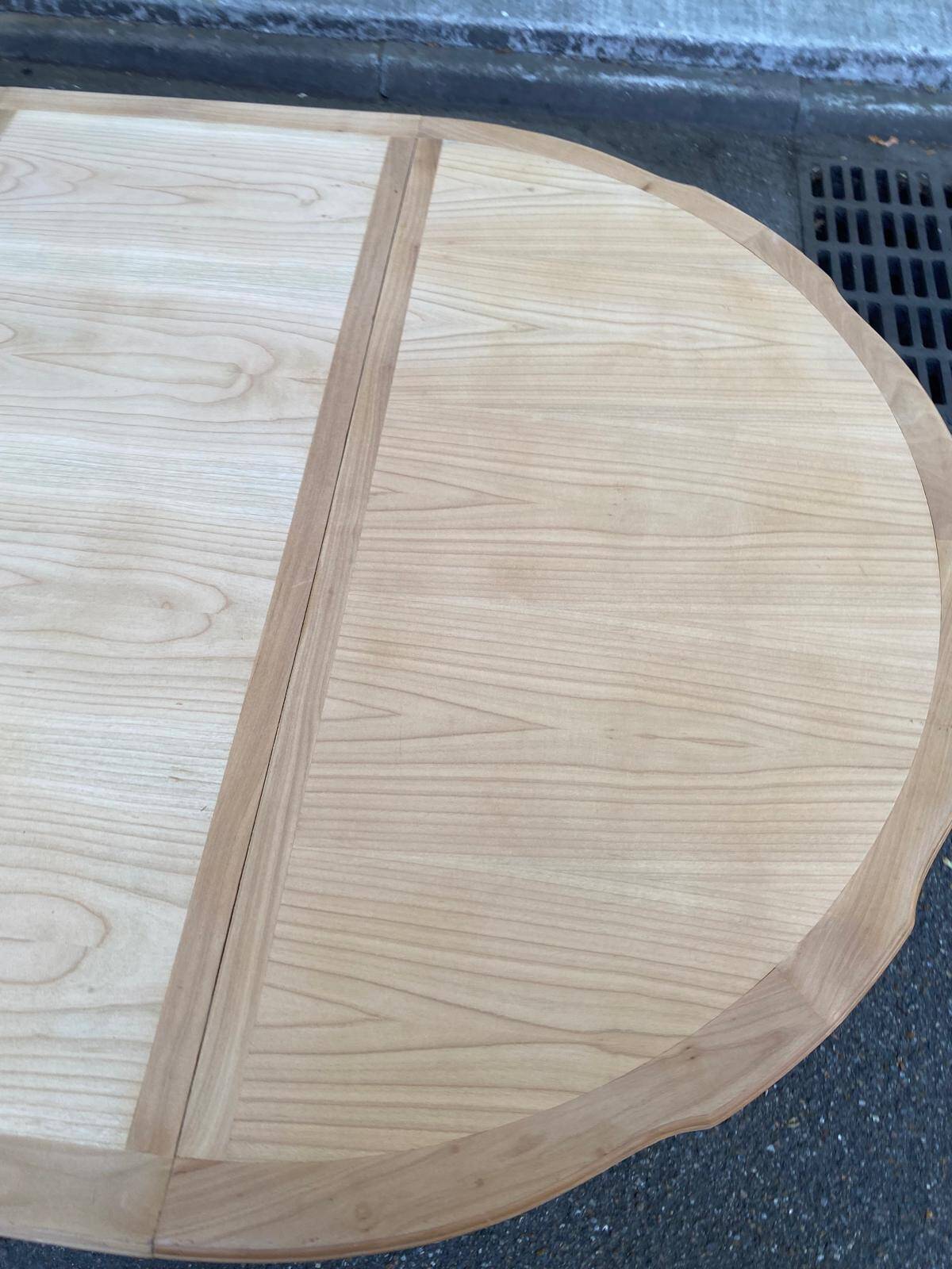 Extendable round table in renovated Louis XVI style, made of light wood, with 2 extensions.