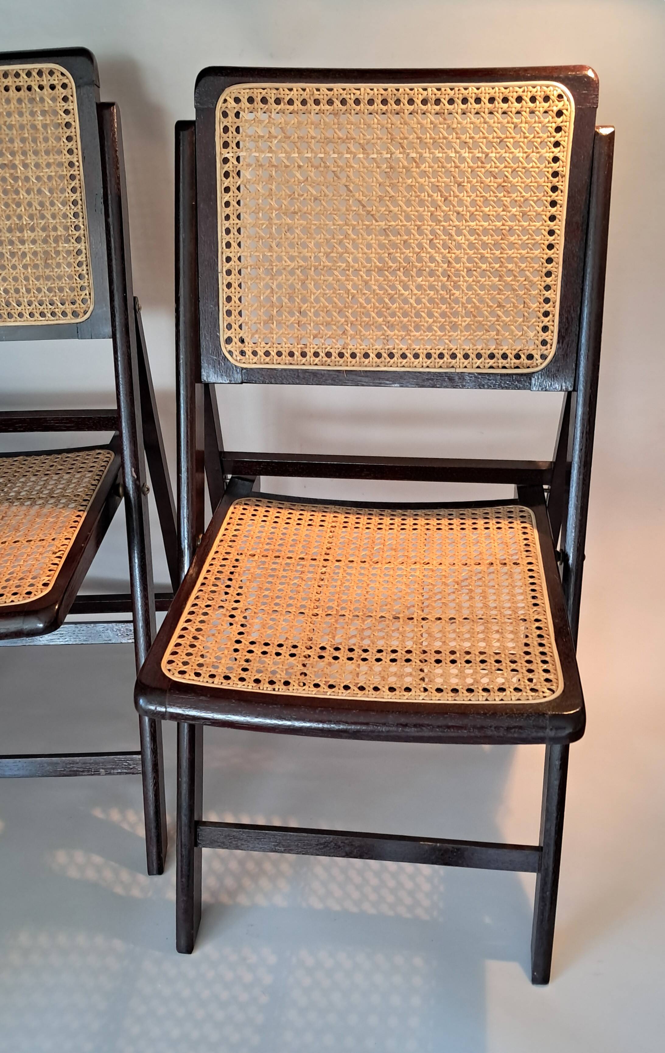 Pair of caned folding chairs from the 1960s in varnished wood.