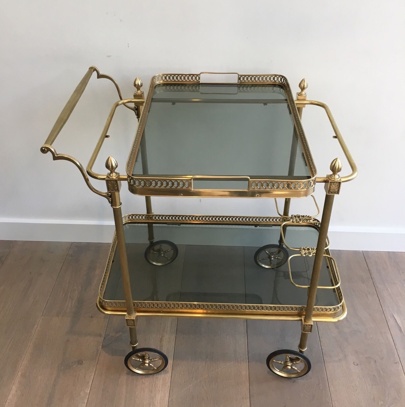Neoclassical style rolling table in brass with blue glass tops