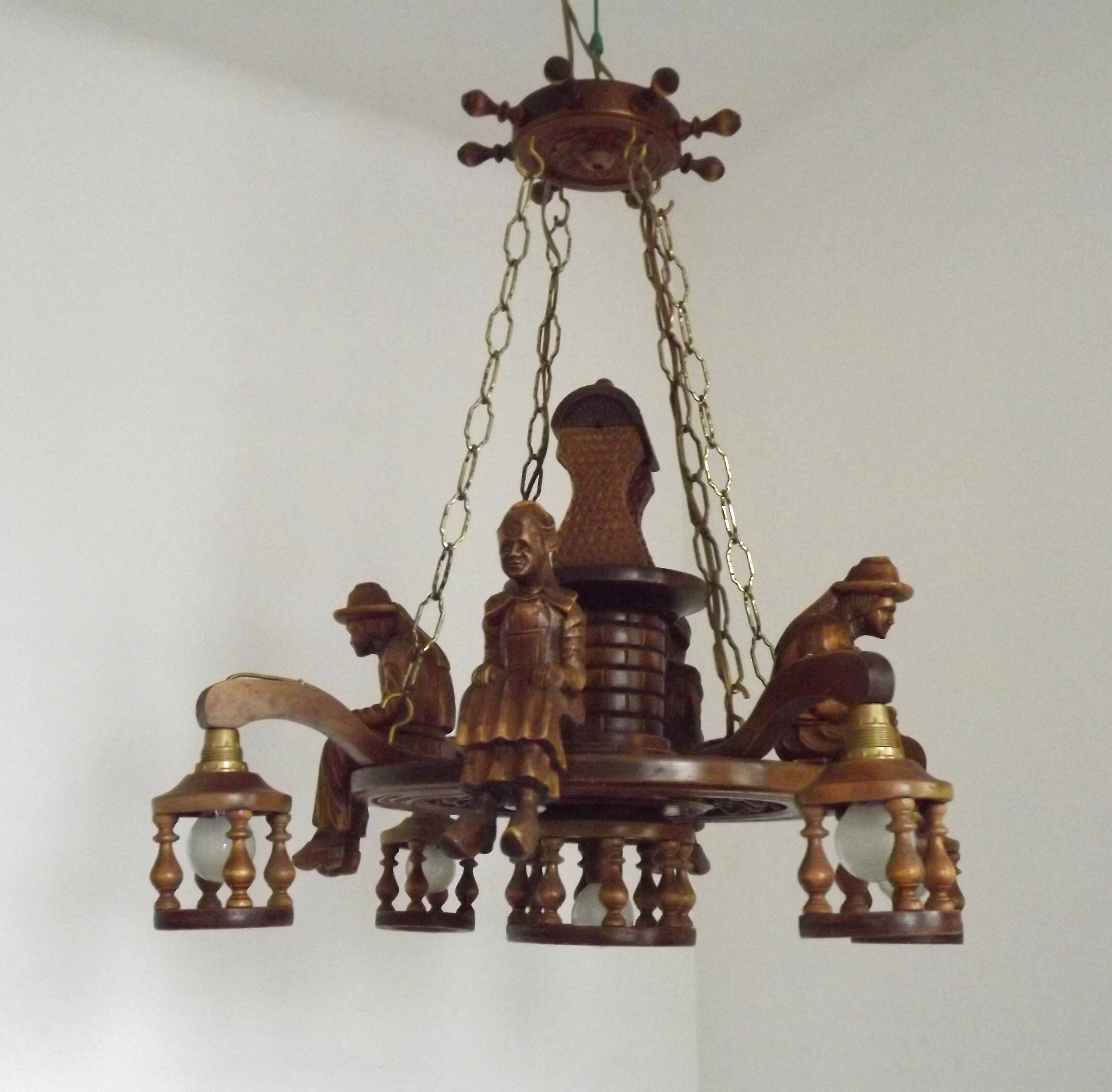 French vintage Breton chandelier with hand-carved figures, well, and lantern lights.