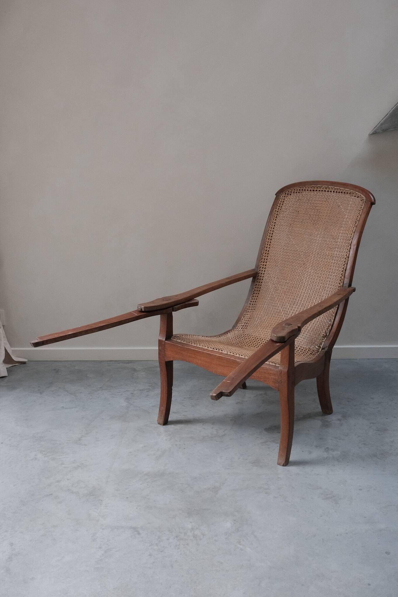 Fauteuil avec assise en cannage et accoudoirs pivotants