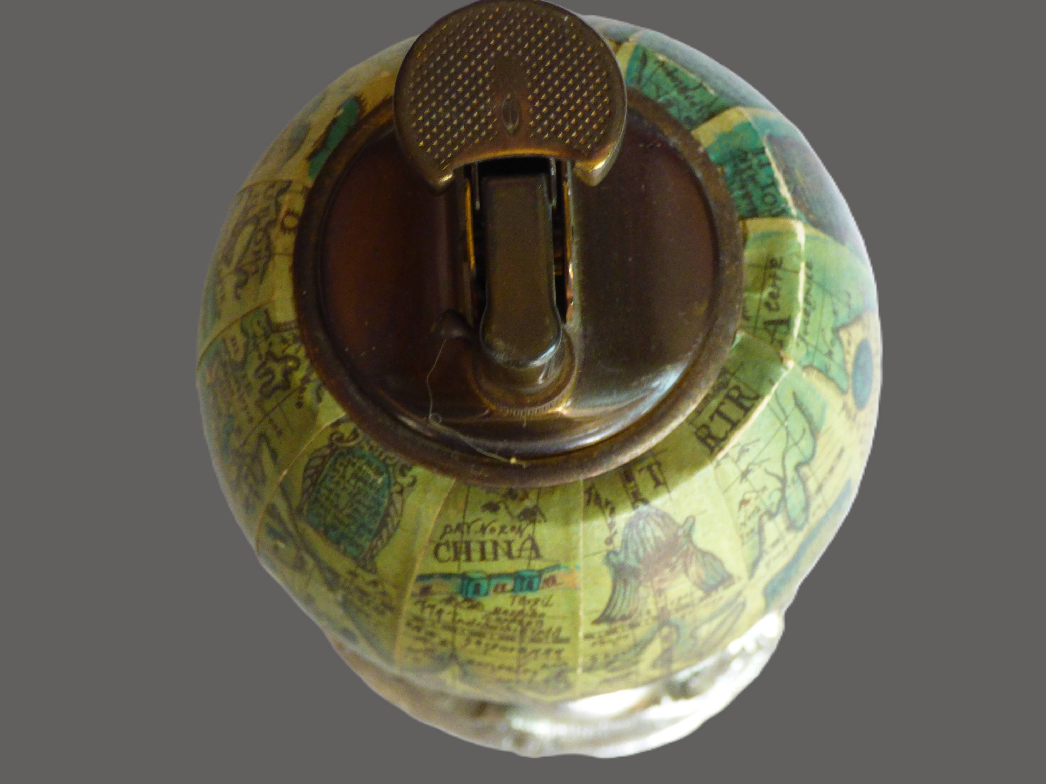 Vintage antique lighter with a globe and silver-plated stand.