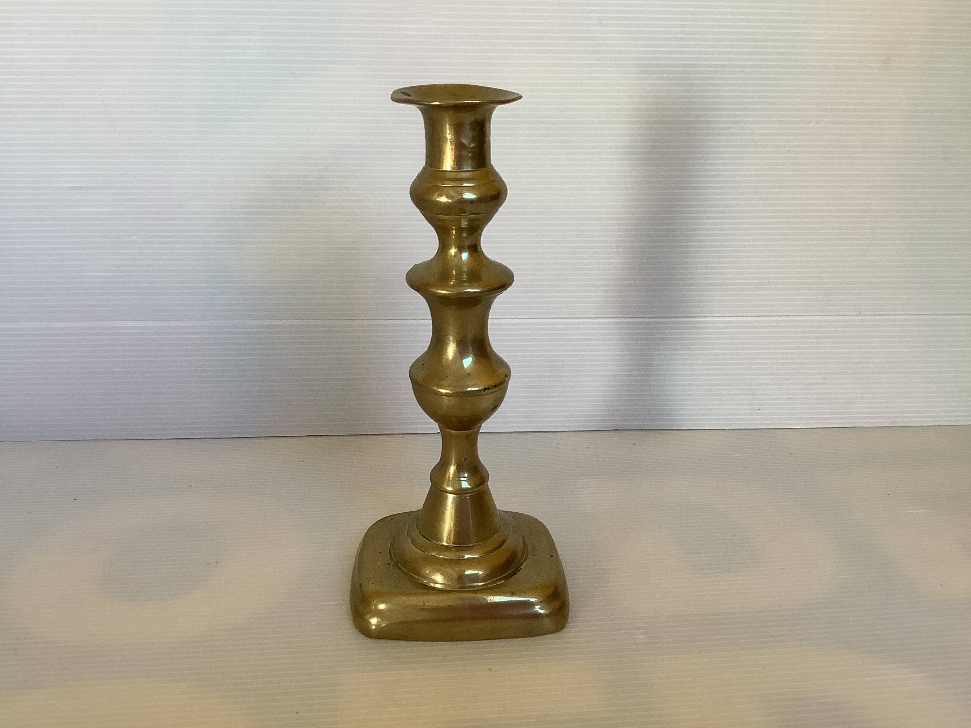 Brass candlestick with a rectangular base.