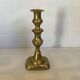 Brass candlestick with a rectangular base.