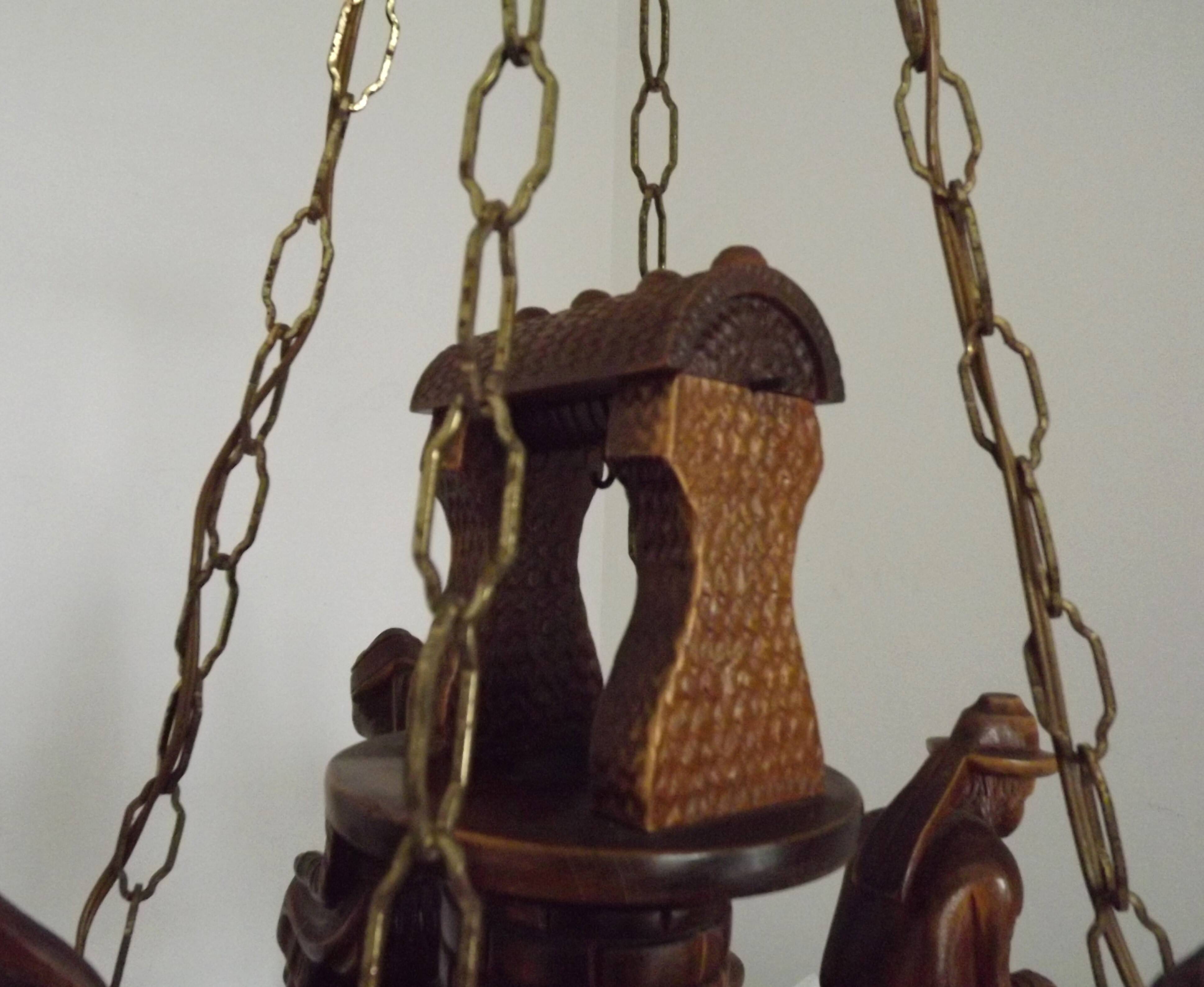 French vintage Breton chandelier with hand-carved figures, well, and lantern lights.