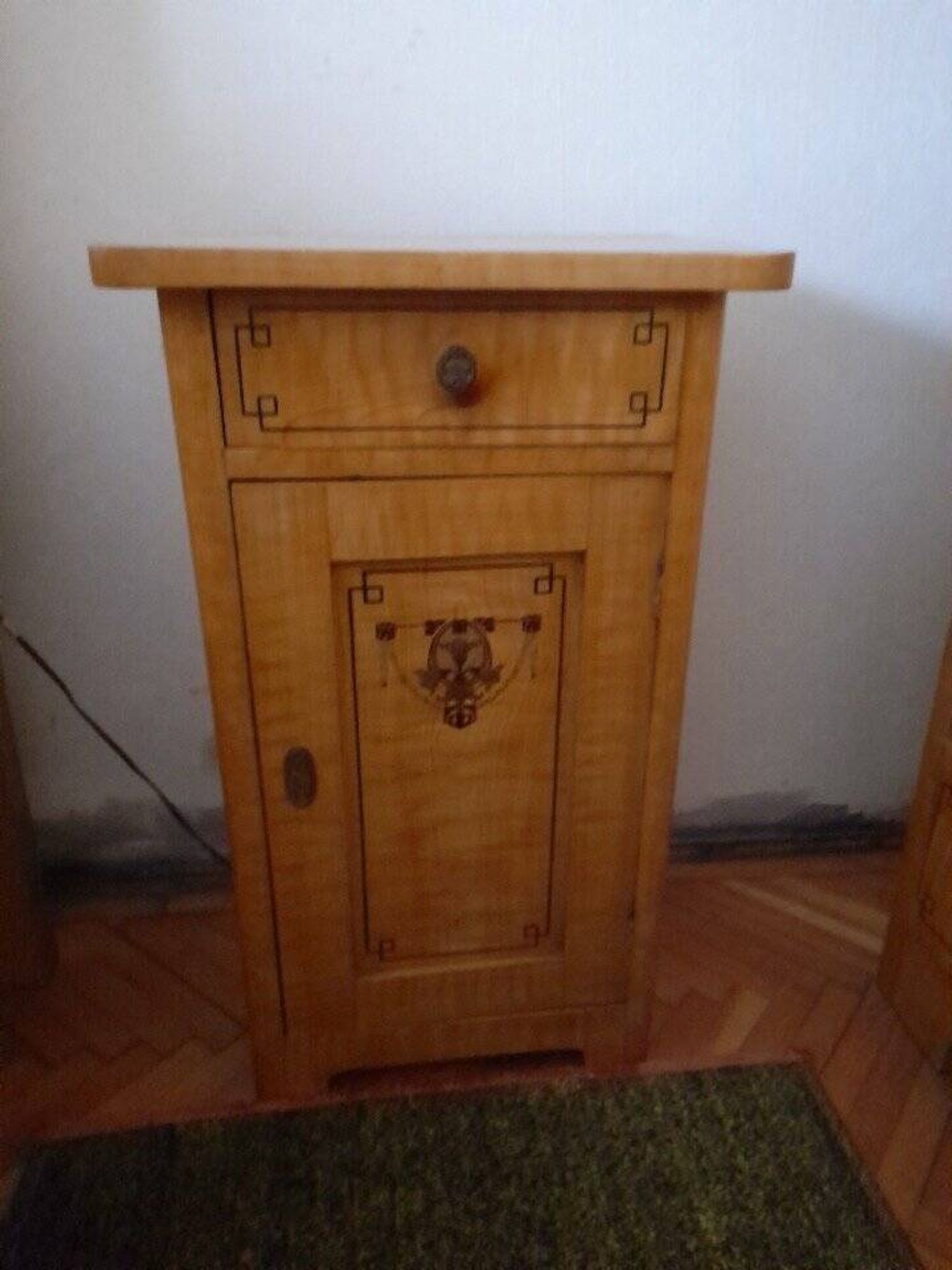 Vintage wooden bedside table painted brown, with a drawer and door, painted decoration from the 1890s.