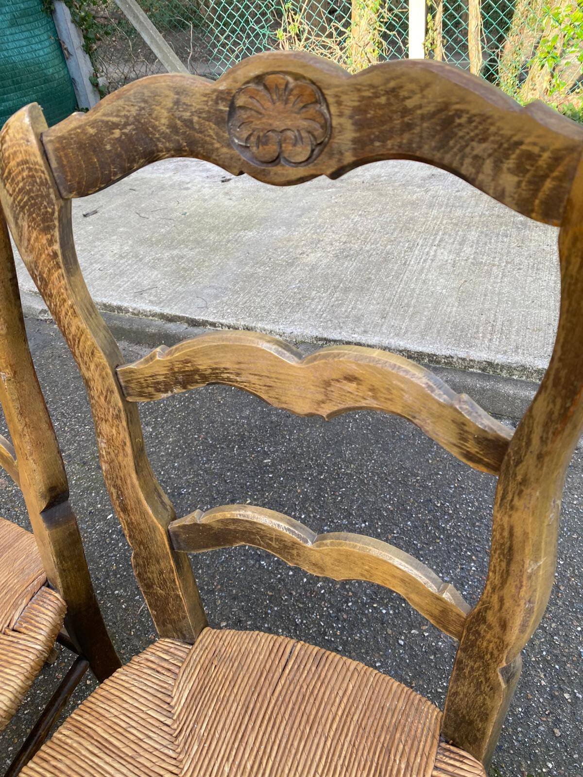2 solid oak carved and rush-seated chairs in the Louis XV style from the 19th century.