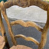 2 solid oak carved and rush-seated chairs in the Louis XV style from the 19th century.