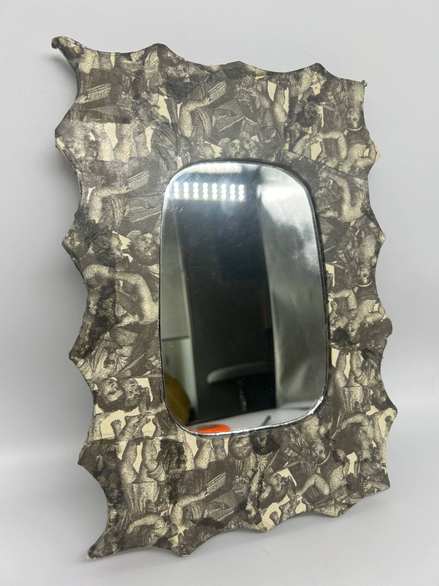 Free-form mirror decorated with cherubs.