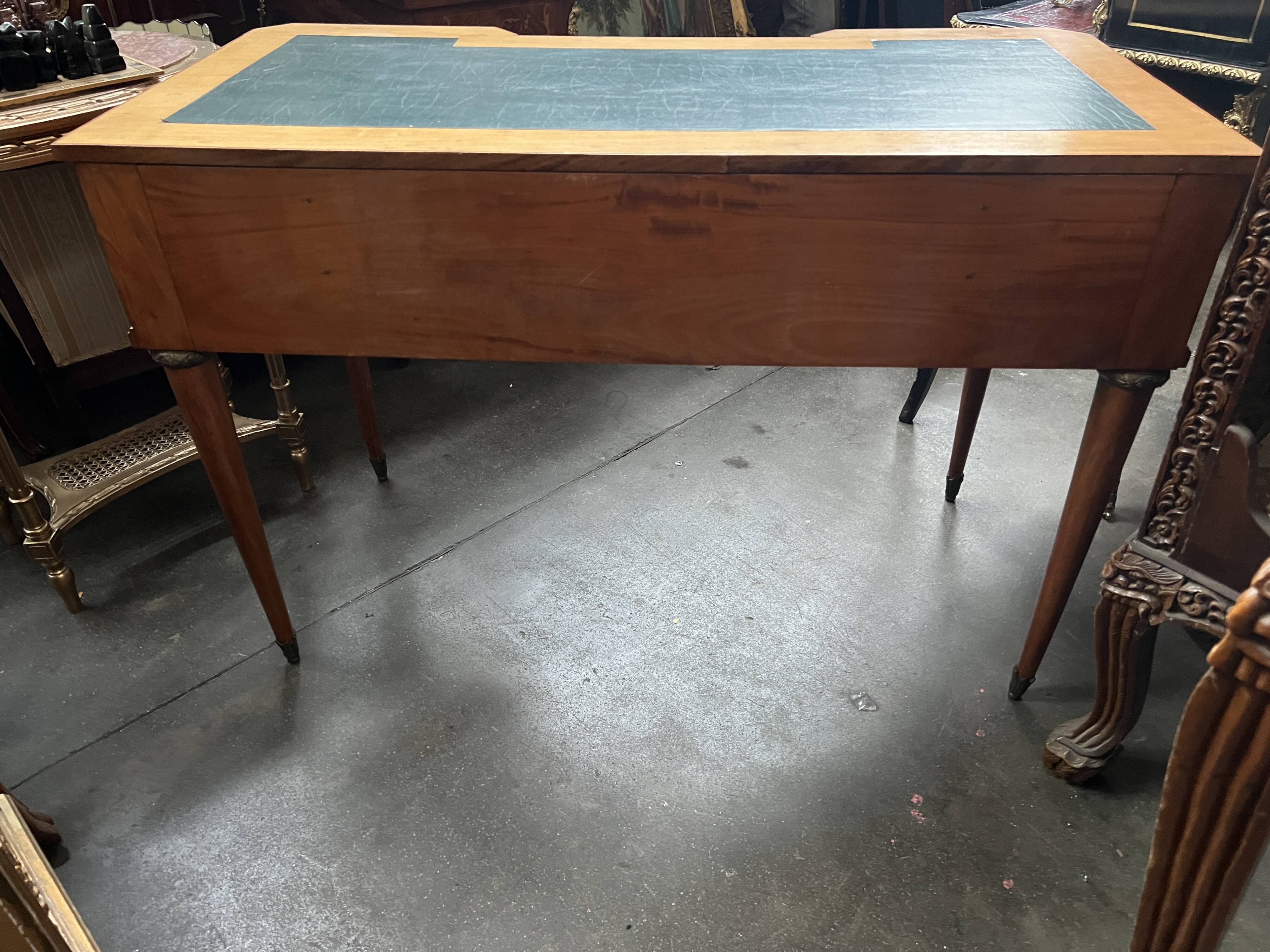 Louis XVI style marquetry desk. The top is decorated with green leather.