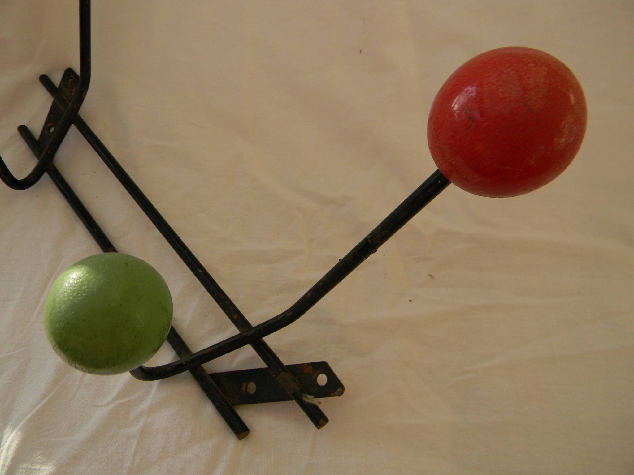 Small wrought iron coat rack with wooden balls.
