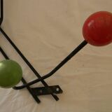 Small wrought iron coat rack with wooden balls.