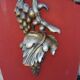 Large three-light wall sconce in silver wood with fruit decoration.