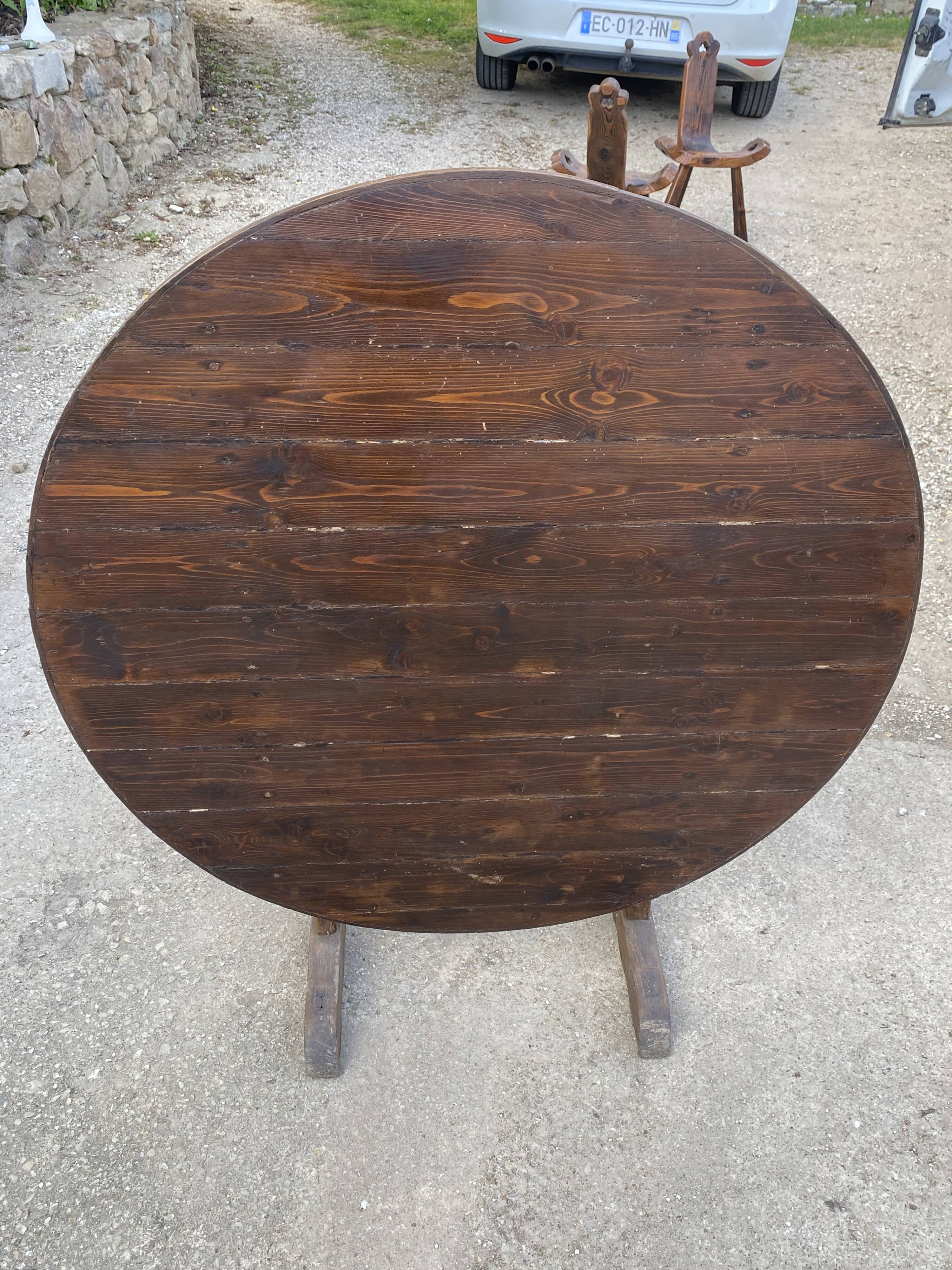 Old folding round winemaker's table with a tilting top.