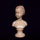 Bust in varnished dish, young girl with bun