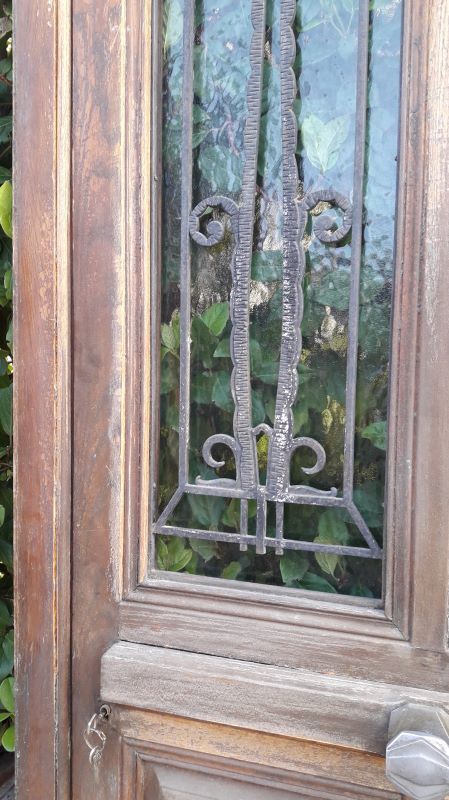Oak entrance door and its frame and transom, wrought iron gates
