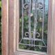 Oak entrance door and its frame and transom, wrought iron gates