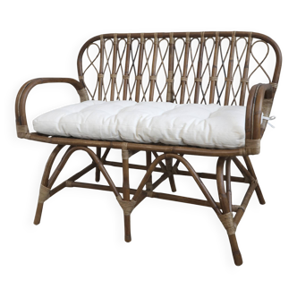 Rattan bench with white cushion