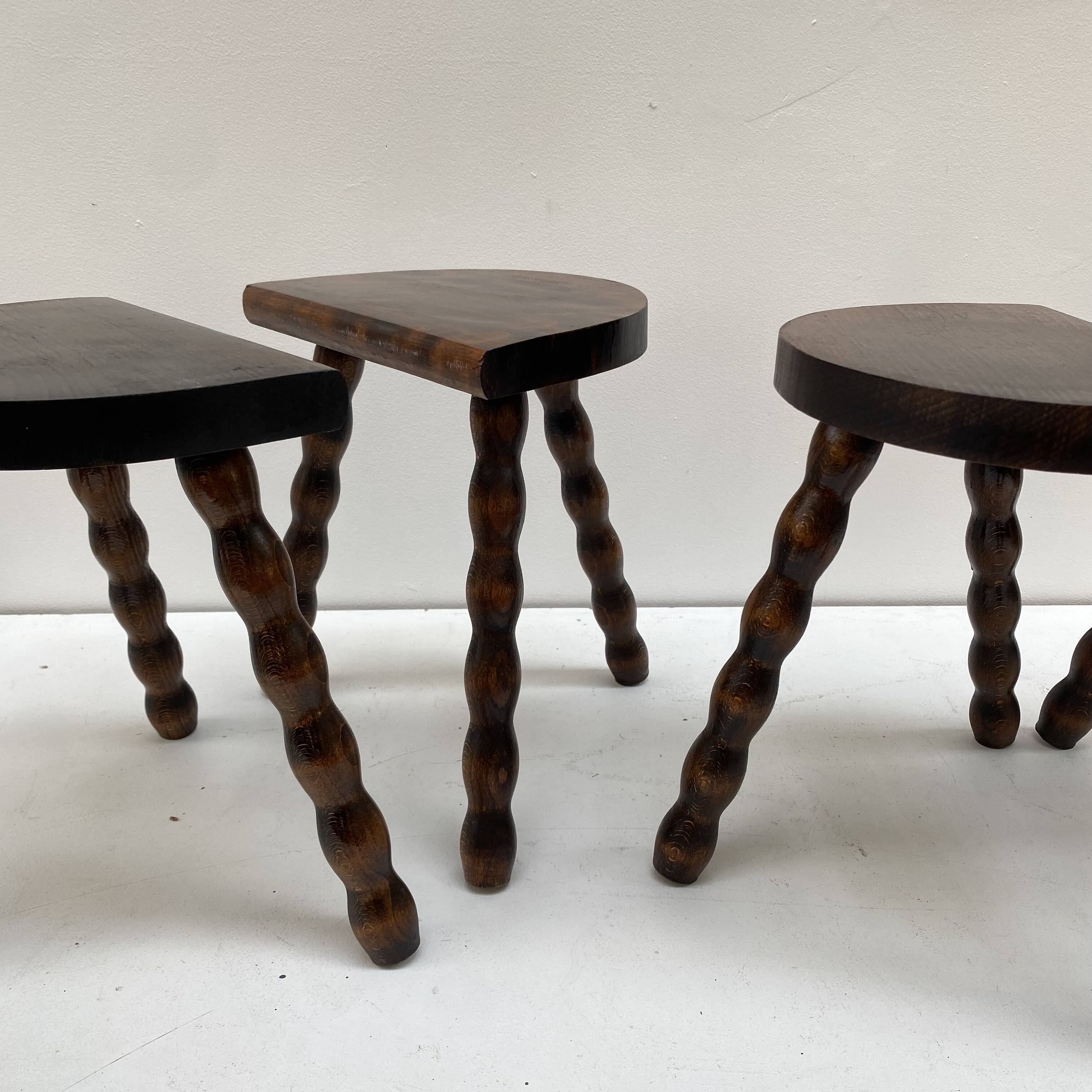 Series of 4 small tripod stools with half-moon seat and beaded turned wood legs