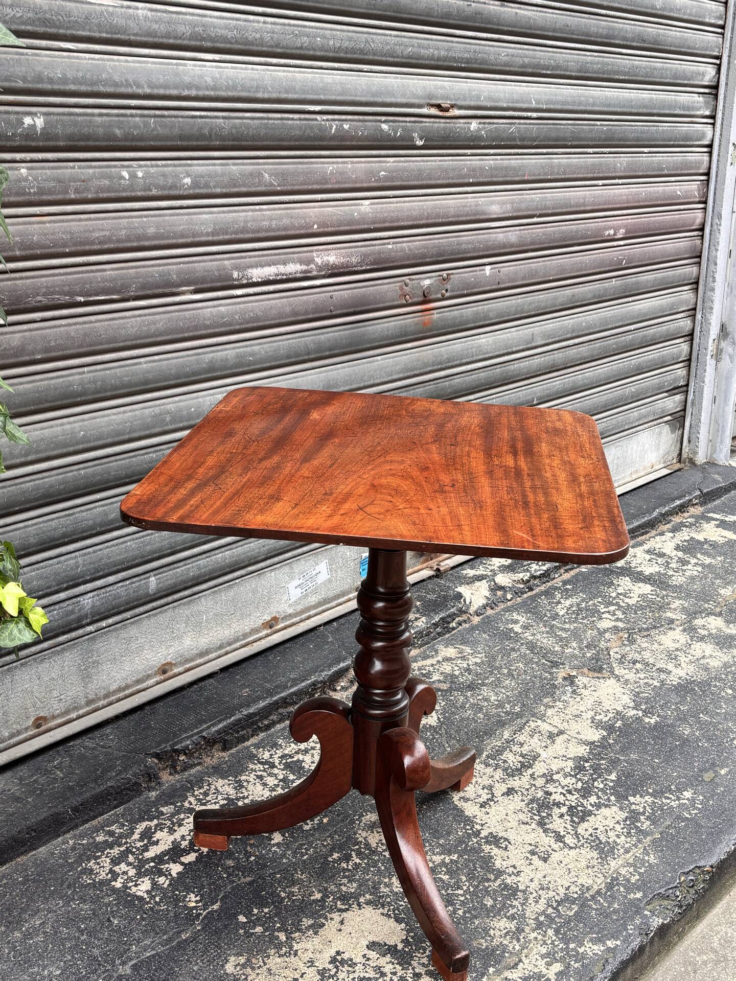 19th-century solid mahogany table with a tilting top and brass mechanism.