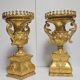 Rare pair of carved and gilded wooden vases, with a refined style inspired by the Empire.