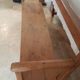 Church bench in fir tree with armrests
