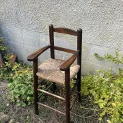 Vintage wooden children's high chair with straw.