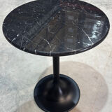 Round marble table with a black metal tulip base.