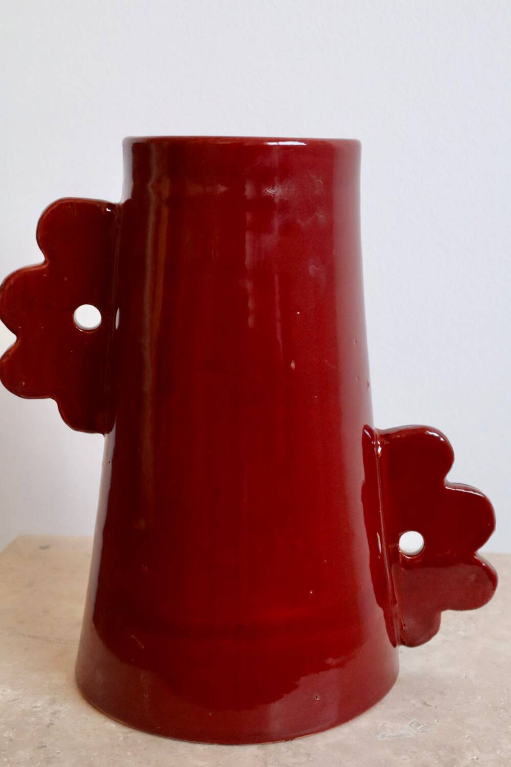 Handmade abstract ceramic vase with asymmetrical handles and burgundy flower
