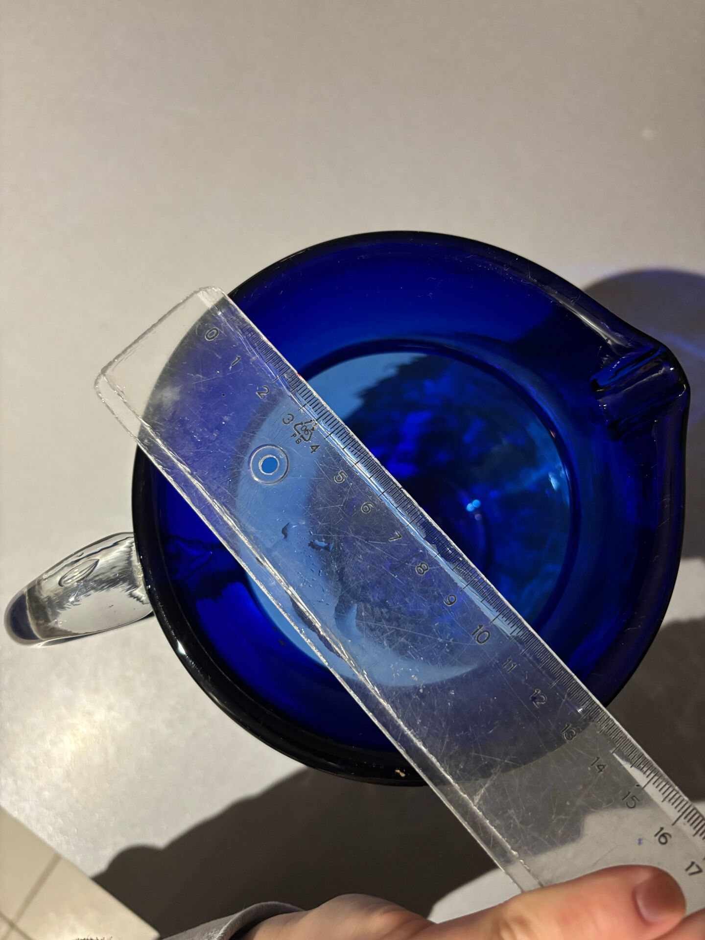 Vintage cobalt blue blown glass jug with a transparent handle.