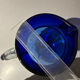 Vintage cobalt blue blown glass jug with a transparent handle.