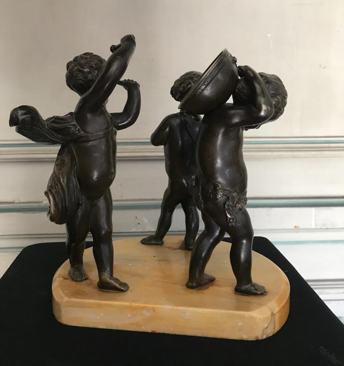 Three musician angels, bronze sculptures on a marble base.